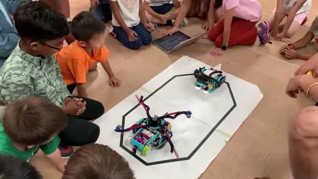 Campers gathered around a robot on a challenge mat